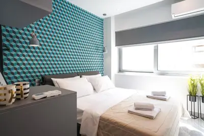 a bedroom with a bed and a blue wall at Athens City Living at Akadimias in Athens