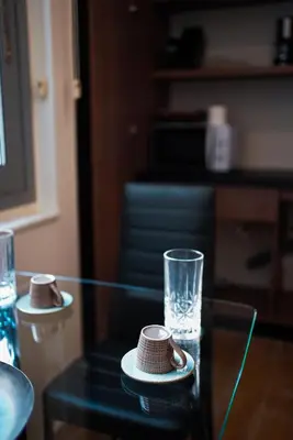 a glass table with two plates and a glass cup at Athens City Living at Akadimias in Athens