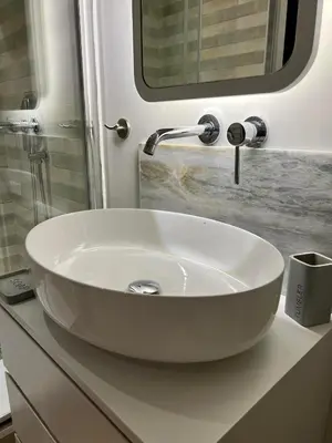 a white sink in a bathroom under a mirror at G&W Luxury Rooms in Athens