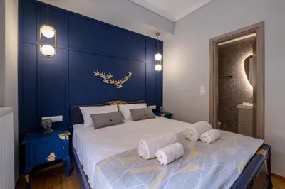 a blue bedroom with a large bed with towels on it at Luxury Penthouse in prime central Athens Thissio by GHH in Athens
