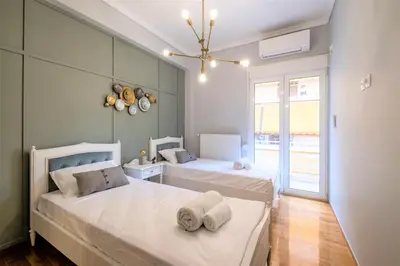 a bedroom with two beds and a large window at Luxury Penthouse in prime central Athens Thissio by GHH in Athens