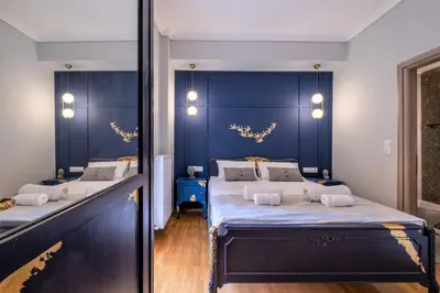 a bedroom with two beds and a blue wall at Luxury Penthouse in prime central Athens Thissio by GHH in Athens