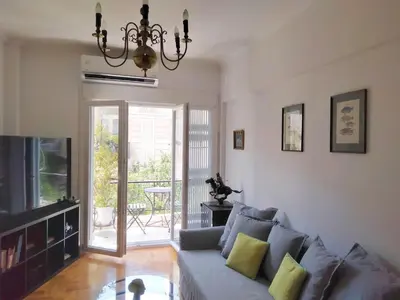 a living room with a couch and a television at AcropolisCozyStay in Athens