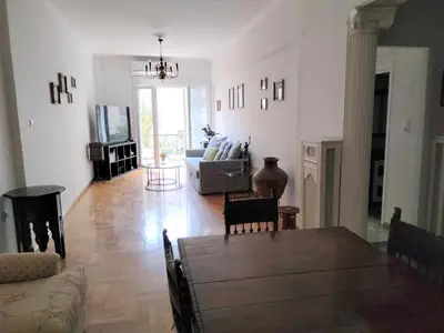 a living room with a table and a couch at AcropolisCozyStay in Athens