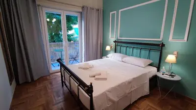 a bedroom with a large bed with a window at Victoria Boutique Studios in Athens