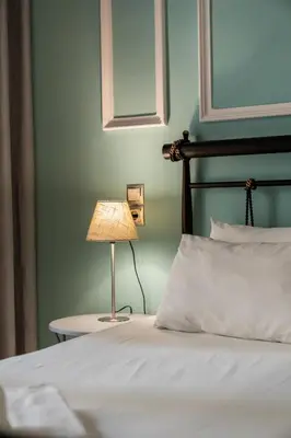 a bedroom with a bed with a lamp on a table at Victoria Boutique Studios in Athens