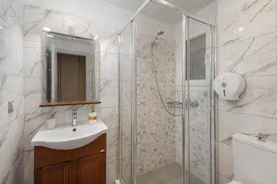 a bathroom with a shower and a sink and a mirror at Victoria Boutique Studios in Athens