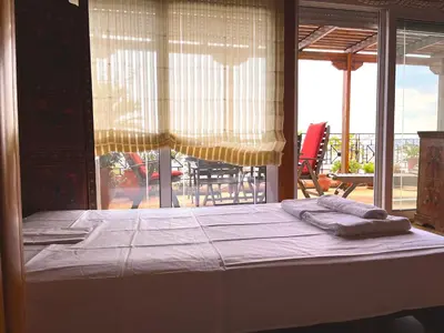 a bed with two towels on it in front of a window at The Best Penthouse View -Sea View Athens Reviera & SNFCC in Athens