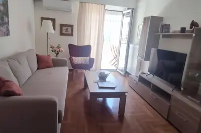 a living room with a couch and a tv and a table at Plaka's Heart in Athens