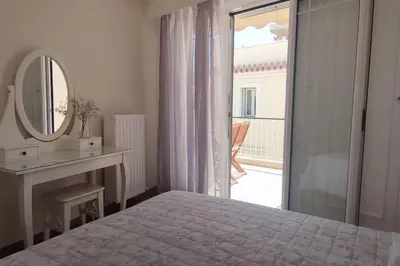a white bedroom with a bed and a mirror at Plaka's Heart in Athens