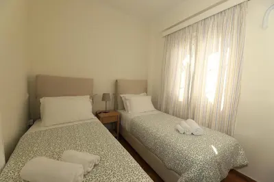 two beds in a small room with a window at Plaka's Heart in Athens