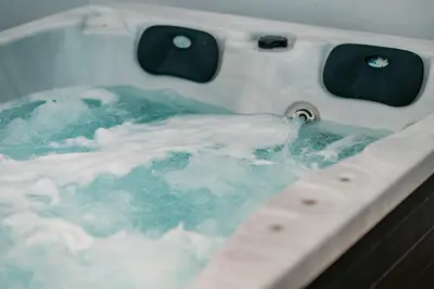 a bath tub filled with blue water with bubbles at Suites with magical view & jacuzzi in Athens