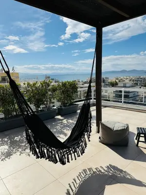 a hammock on a roof with a view of the city at Suites with magical view & jacuzzi in Athens