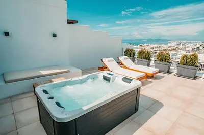 a bathroom with a hot tub on a balcony at Suites with magical view & jacuzzi in Athens
