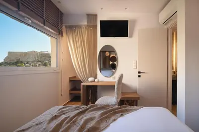a bedroom with a bed and a desk and a mirror at Apollonos at Heart of Plaka in Athens