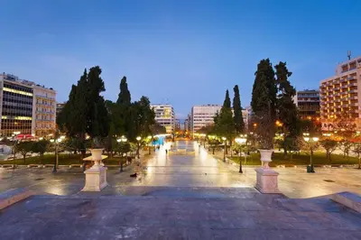 a park with trees and street lights at night at Apollonos at Heart of Plaka in Athens