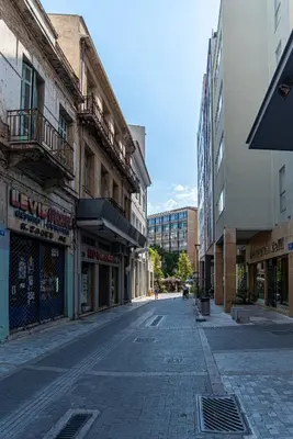 an empty street in a city with buildings at Central Calm Apartment in Athens