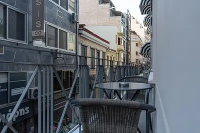 a balcony with chairs and a table on a street at Central Calm Apartment in Athens