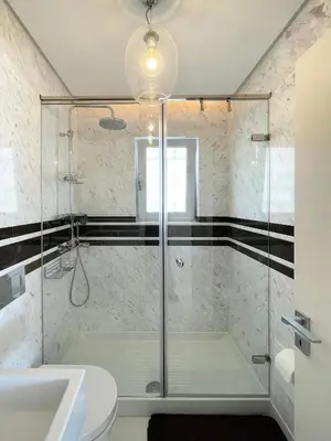 a bathroom with a shower and a toilet and a sink at Blue Bay Vouliagmeni Luxury Apartment in Athens