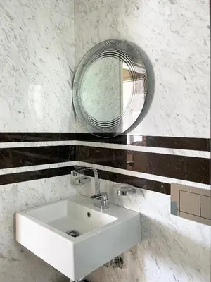 a bathroom with a white sink and a mirror at Blue Bay Vouliagmeni Luxury Apartment in Athens