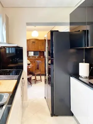 a kitchen with a black refrigerator in a kitchen at Blue Bay Vouliagmeni Luxury Apartment in Athens