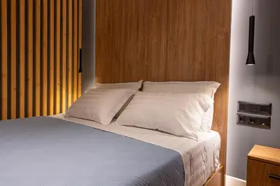 a bed with white pillows and a wooden headboard at A&N Athens Luxury Apartments - Akadimou in Athens
