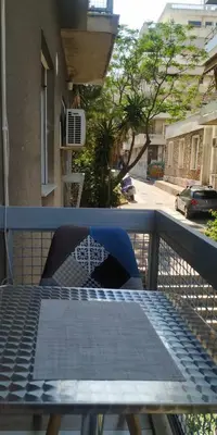 a balcony with a table and an umbrella on a railing at kynosargous square's apartment in Athens