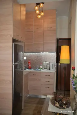 a kitchen with wooden cabinets and a stainless steel refrigerator at kynosargous square's apartment in Athens