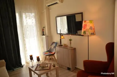 a living room with a table and a tv on the wall at kynosargous square's apartment in Athens