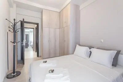 a bedroom with a white bed with two white towels at Filoxenia MG Projects Near Acropolis Veeikou in Athens
