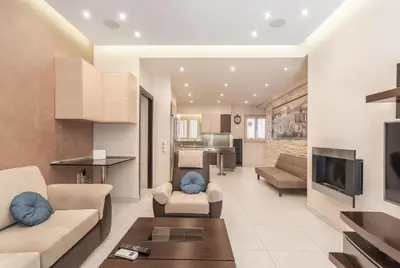 a living room with a couch and a table and a tv at Filoxenia MG Projects Near Acropolis Veeikou in Athens