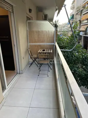 a patio with a table and chairs on a balcony at Filoxenia MG Projects Near Acropolis Veeikou in Athens