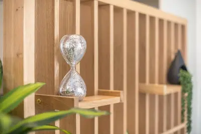 a silver hour glass sitting on a wooden shelf at Luxury Loft with a Balcony by CloudKeys in Athens