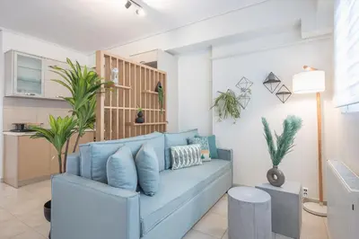 a blue couch in a living room with plants at Luxury Loft with a Balcony by CloudKeys in Athens