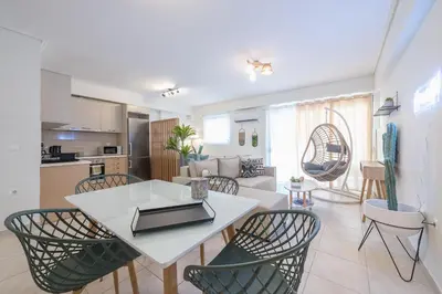 a kitchen and living room with a white table and chairs at Luxury Loft with a Balcony by CloudKeys in Athens