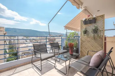 a balcony with chairs and a table with a view at Luxury Loft with a Balcony by CloudKeys in Athens