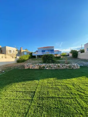 a large yard with a building in the background at The Dona House in Vaia