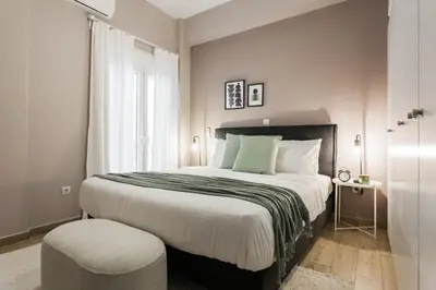 a bedroom with a large bed and a chair at Gorgeous 1BR Apartment in Kolonaki by UPSTREET in Athens