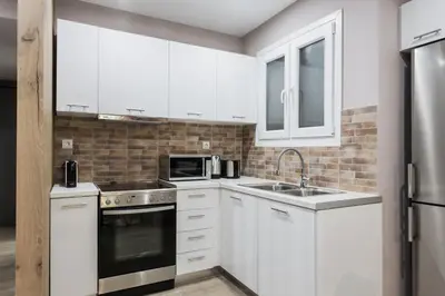 a white kitchen with a sink and a microwave at Gorgeous 1BR Apartment in Kolonaki by UPSTREET in Athens