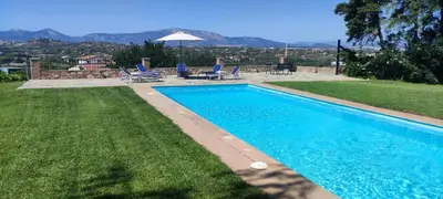a swimming pool in a yard with chairs and a table at Ellie's StoneHouse Gianapa, Porto Rafti, Greece, 190 03, GR in Porto Rafti