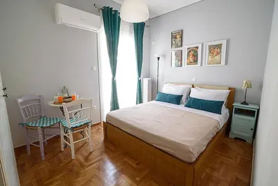 a bedroom with a bed and a table and a window at jack daniel's appartment in Athens