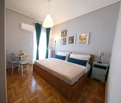 a bedroom with a bed and a table and a window at jack daniel's appartment in Athens