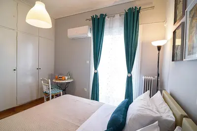 a bedroom with a bed and a window with a table at jack daniel's appartment in Athens