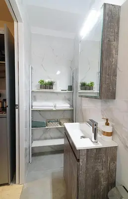 a white bathroom with a sink and a mirror at jack daniel's appartment in Athens
