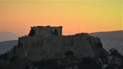 a building on top of a mountain with a sunset at Work or Vacation in shared apartment in Athens