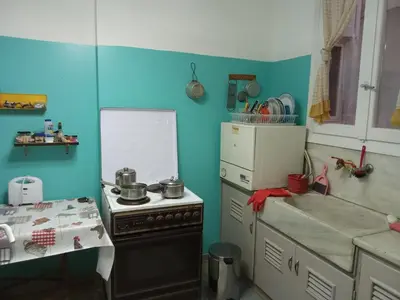 a kitchen with a stove and a white and blue wall at Work or Vacation in shared apartment in Athens
