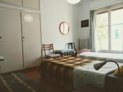 a hotel room with two beds and a window at Work or Vacation in shared apartment in Athens