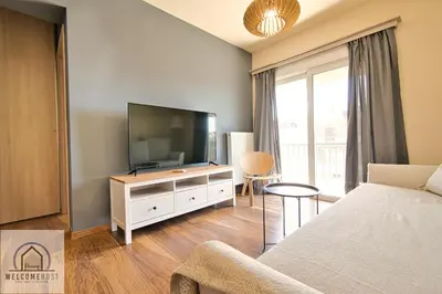 a living room with a flat screen tv and a couch at Bright & Restful! in Athens