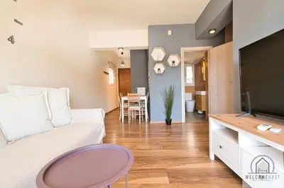 a living room with a couch and a tv at Bright & Restful! in Athens