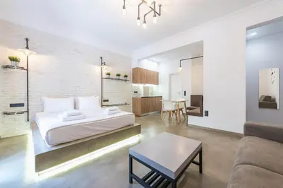 a bedroom with a bed and a living room at Stylish 1BR apartment in the heart of Koukaki in Athens